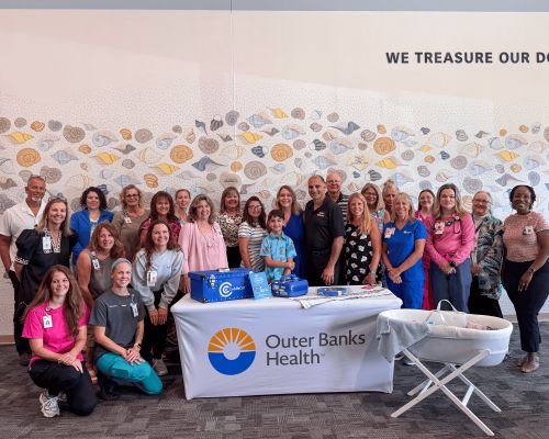 Ashlie’s Embrace founders Erin and Tony Maroon with family, friends and hospital staff at a CuddleCot dedication at Outer Banks Health in memory of Rick Hopkins.