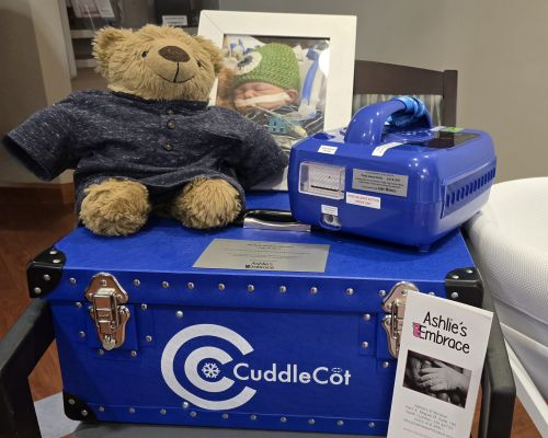 CuddleCot donated to an Ohio hospital in memory of Nolan Straky, displayed with his photograph and a teddy bear at the dedication.