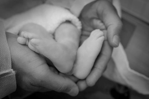 Ashlie Cathren’s tiny feet resting in her father Tony’s hands shortly after her birth.